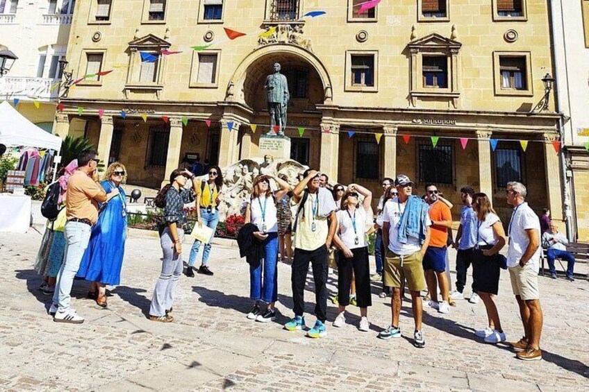 A group of people standing in a public square with a historical building in the background. 4