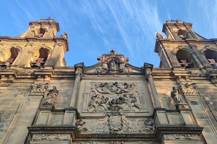 A historic building with ornate carvings and two bell towers. 5