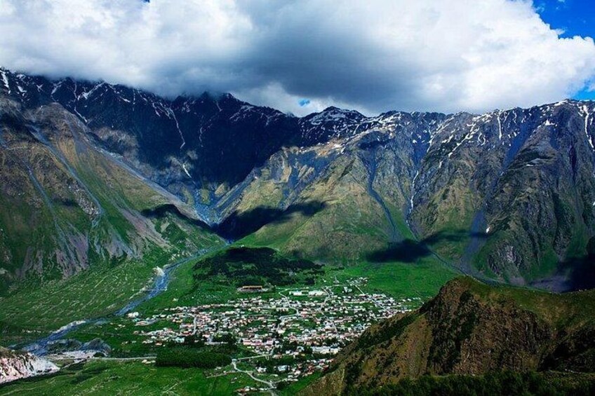 A mountainous landscape with a valley and a small settlement. 5