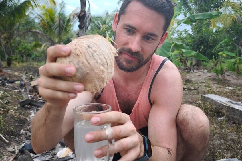 A person holding a coconut and a glass. 4