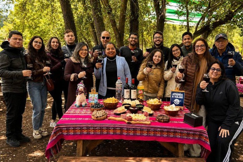 A group of people gathered around a table with food and drinks in an outdoor setting. 4