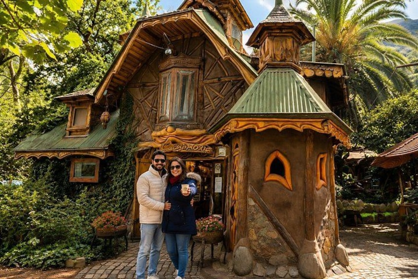 A rustic wooden house with a green roof, surrounded by lush greenery and palm trees. 3
