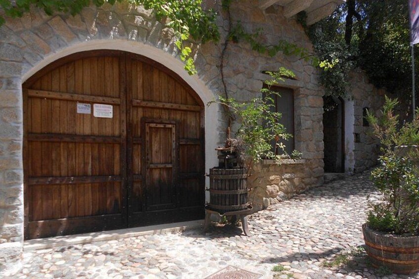 A stone building with a wooden door, a stone archway, and a cobblestone path. 4