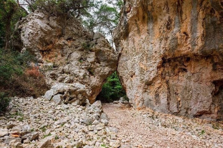 A rocky terrain with a narrow passage between two large rock formations. 4