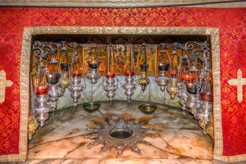 A religious iconostasis with multiple icons, candles, and a central bowl. 5