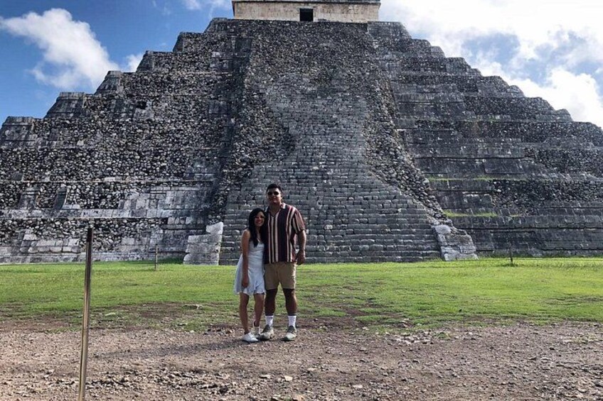 Eine große, alte Pyramide, vor der eine Person und ein Kind stehen. 5
