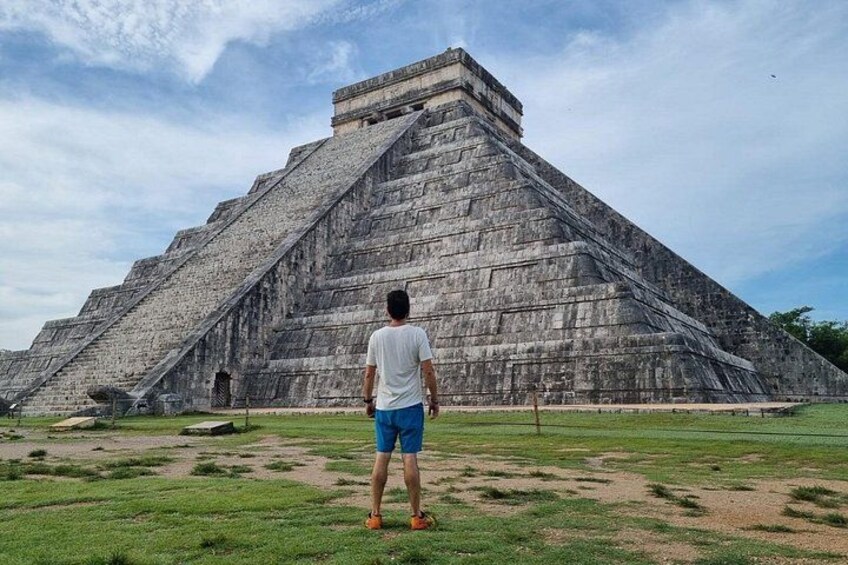Eine große Pyramidenstruktur, vor der eine Person steht. 4