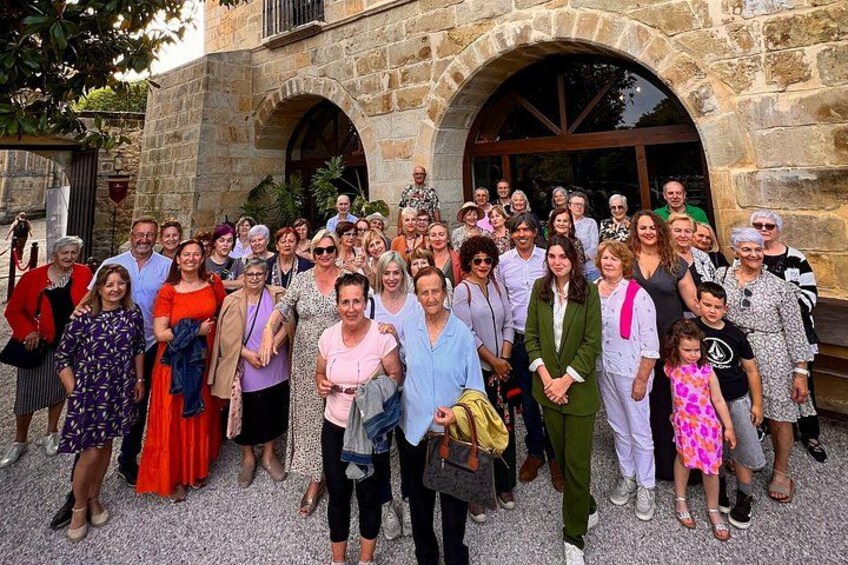 A group of people standing in front of a stone building with arches. 4