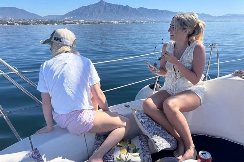Two people on a boat with a mountainous landscape in the background. 3