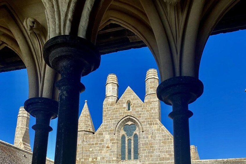 A stone church with a pointed arch and a clear blue sky. 5
