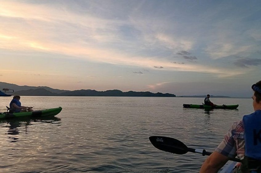 Dos kayaks sobre aguas tranquilas, con una persona remando en primer plano y otra en kayak al fondo. 2