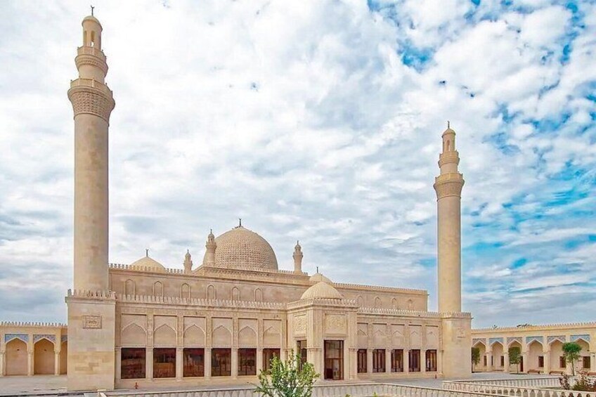 A mosque with two minarets, a large central dome, and a courtyard. 5