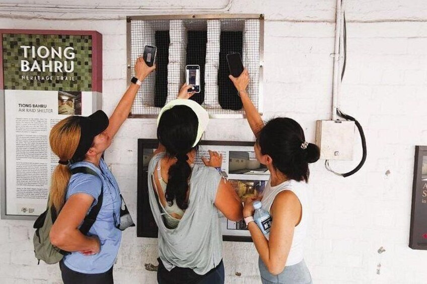 Tres personas tomando fotografías junto a un panel informativo de una ruta histórica. 2