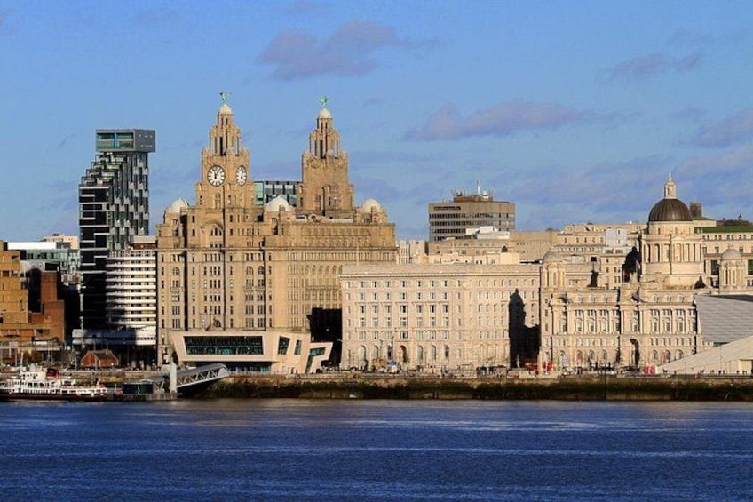 A waterfront cityscape with historic buildings, a modern bridge, and a river. 4