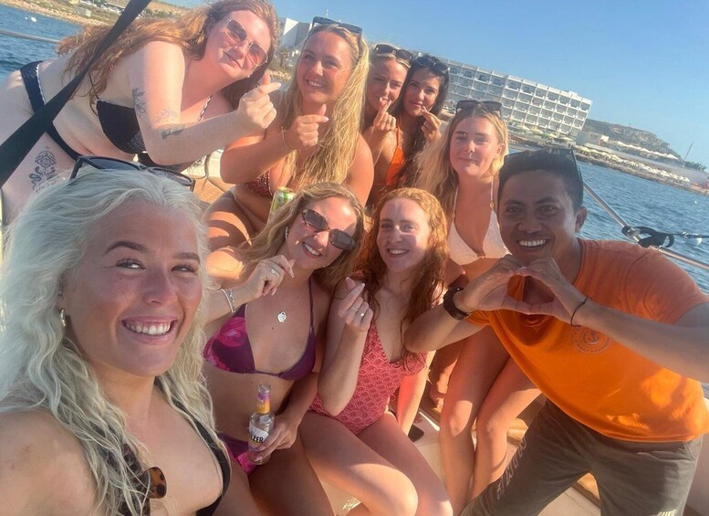 A group of people on a boat with a coastal backdrop. 4