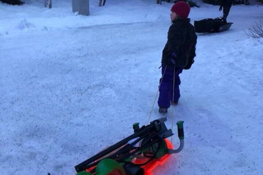 Un niño empujando un motor de nieve sobre un terreno nevado. 4