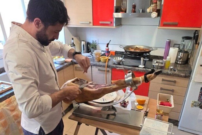 A person preparing food in a kitchen with red cabinets and various cooking utensils. 2