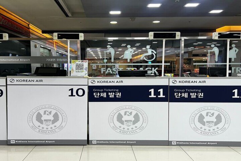 A ticketing area at an airport with signs for Korean Air and group ticketing. 2