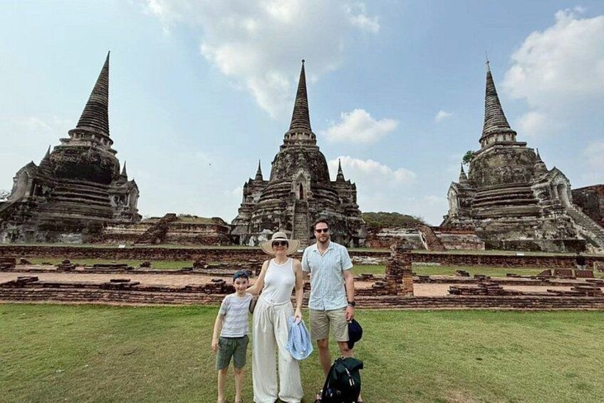 Een gezin staat voor de ruïnes van een oud tempel met meerdere torens. 3