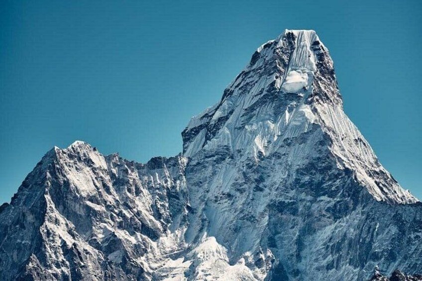 A snow-covered mountain peak with sharp ridges and a clear sky. 4
