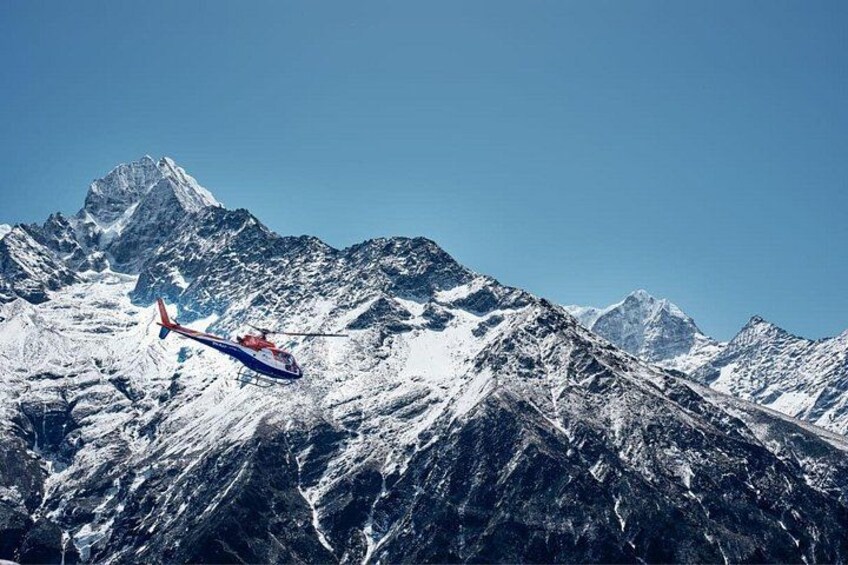A helicopter flying over snow-covered mountains. 2