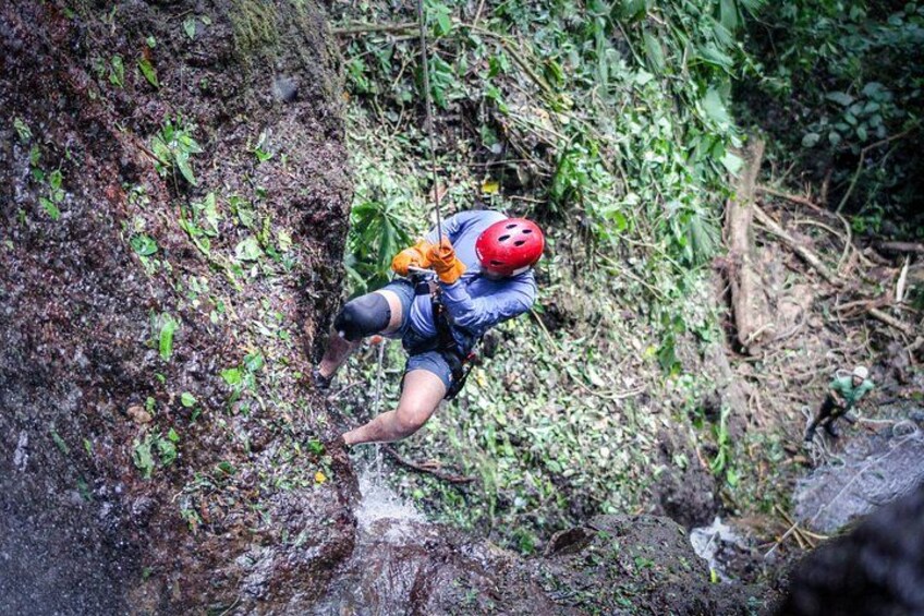 A person rappelling down a rocky cliff. 2