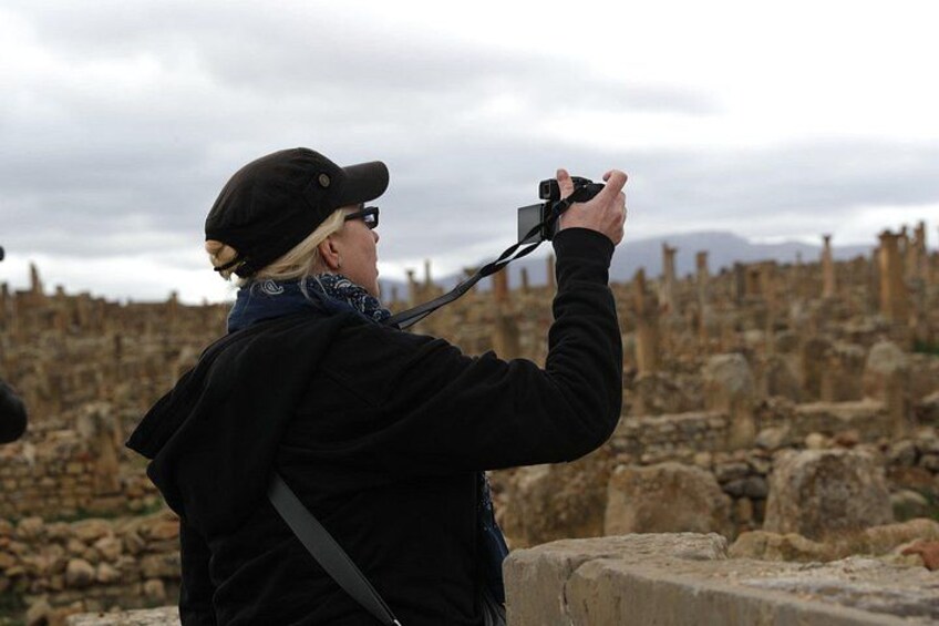 A person taking a photo of ancient ruins with a camera. 2