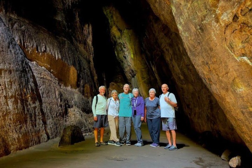 A group of people standing in a cave with stalactites. 1