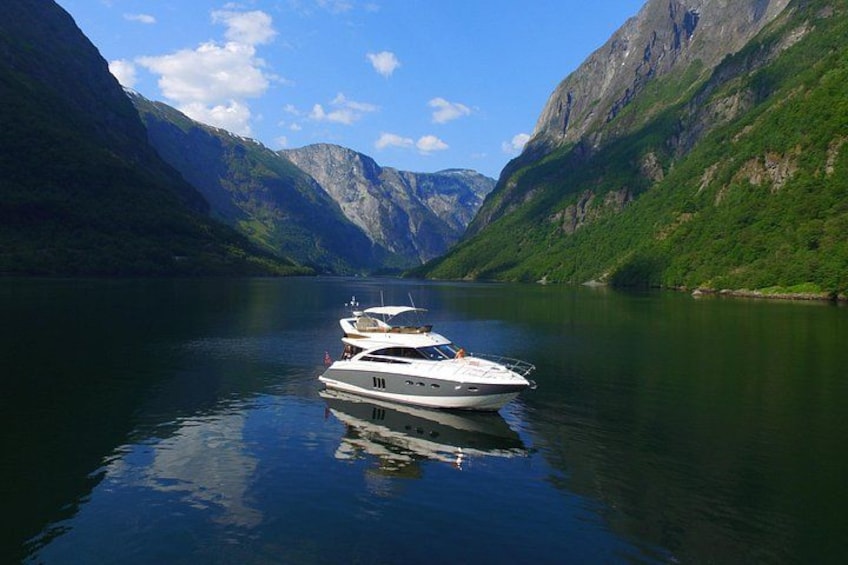 Un lago tranquilo con barcos, rodeado de montañas verdes. 1