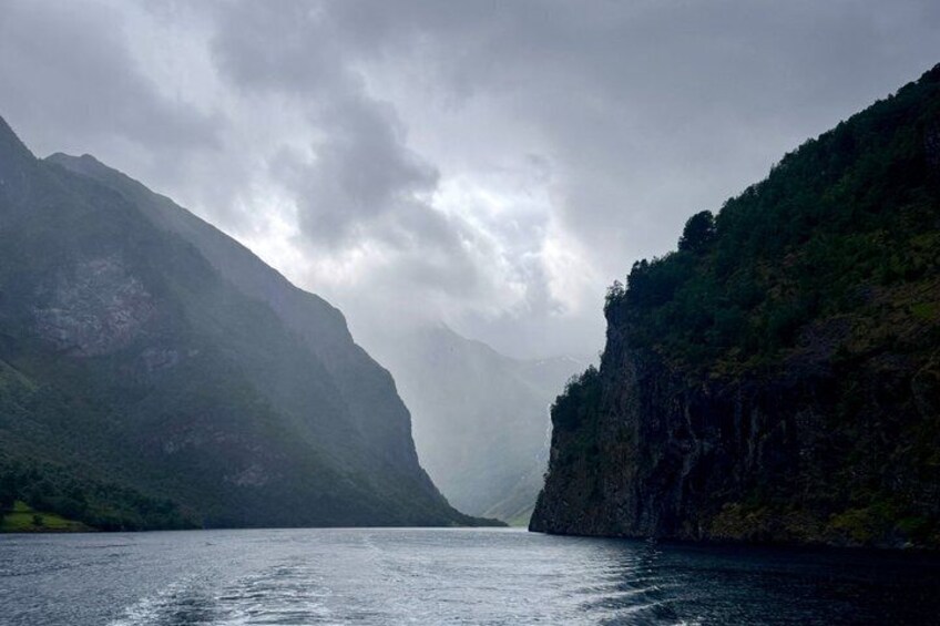 A river surrounded by steep cliffs under a cloudy sky. 5