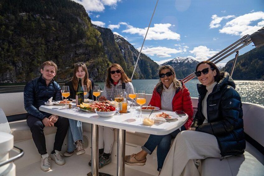A group of people on a boat with a mountainous landscape in the background. 3