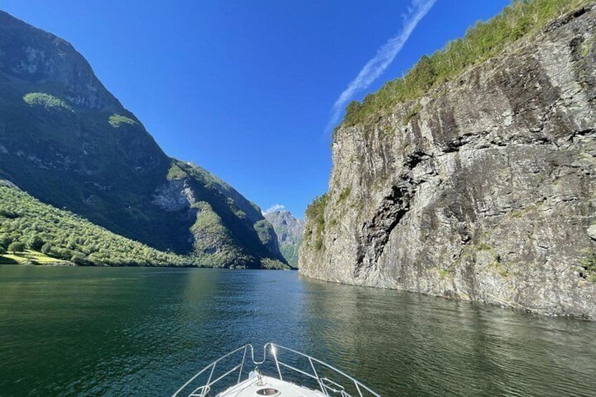 A boat on a calm river surrounded by steep cliffs. 3