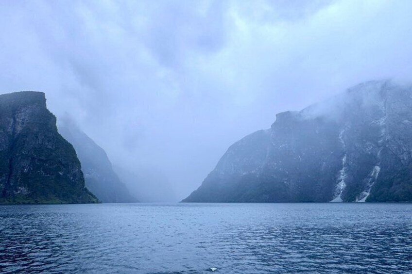 A fjord with steep cliffs and a misty atmosphere. 2