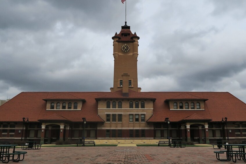A large brick building with a clock tower and a red roof. 5