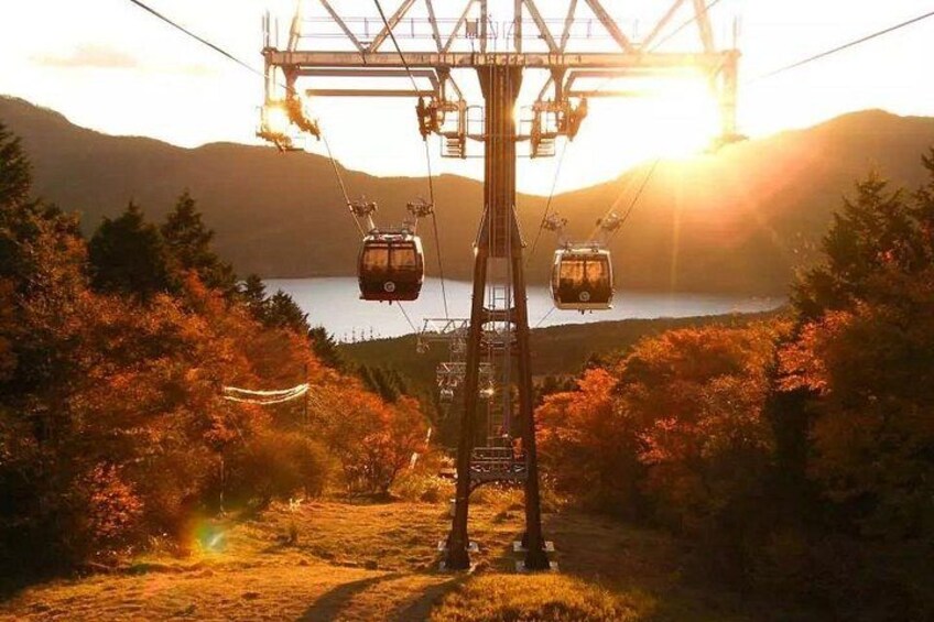 A cable car system with cables and towers, a lake, and autumn foliage. 5