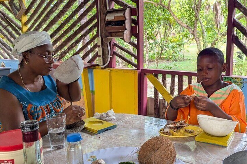 Two people sitting at a table outdoors, eating food. 5