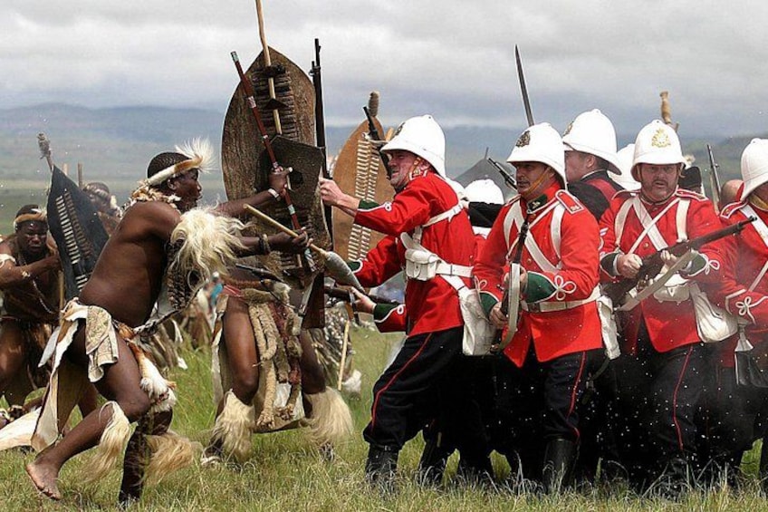 A historical reenactment with participants in red uniforms and traditional attire. 4