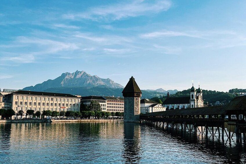 A lake with buildings and a mountain in the background. 3