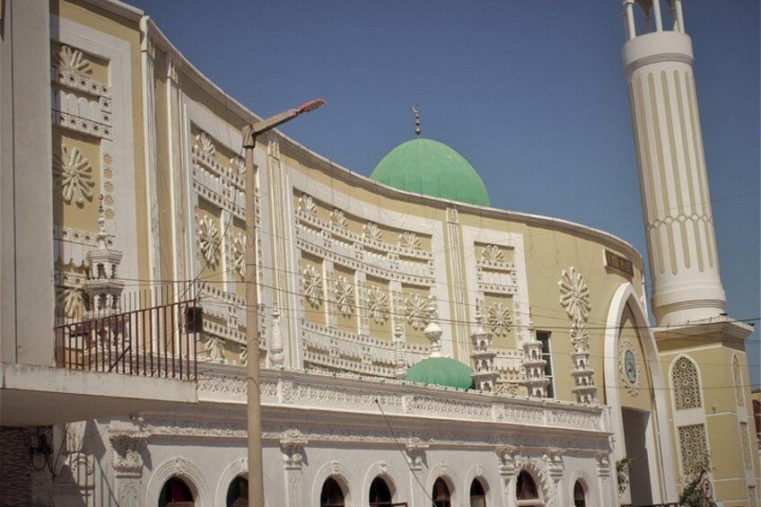 Une mosquée dotée d’un dôme vert et d’un minaret imposant. 2