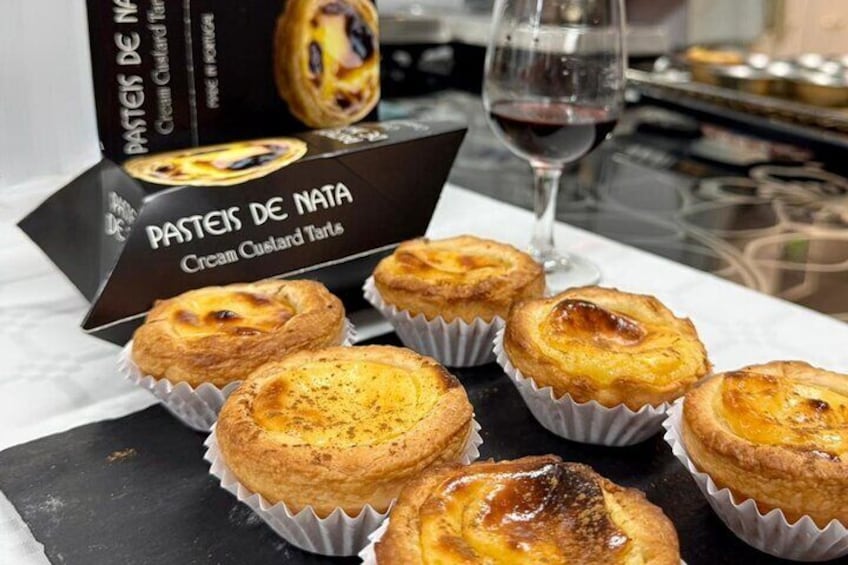 En låda med Pastéis de Nata, innehållande sex bakverk, står på ett bord. 5