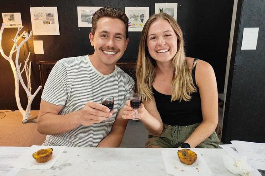 Two people sitting at a table with a dessert and drinks. 2