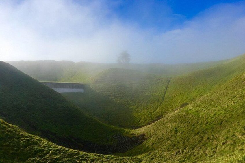 Rolling hills, a valley, and a building in the distance. 3