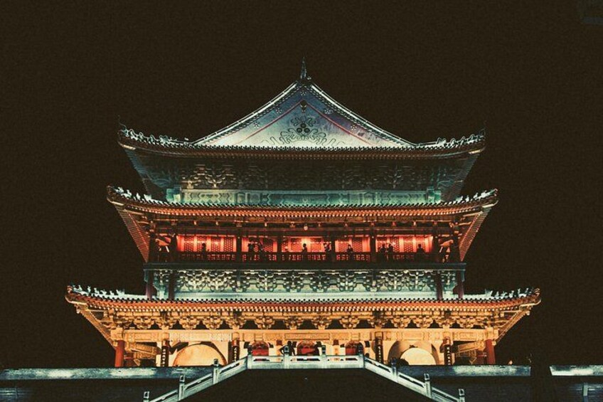 A traditional multi-tiered pagoda at night, illuminated with warm lighting. 4