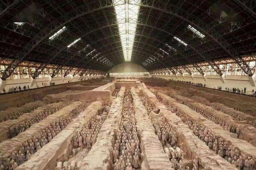 A large indoor space with rows of terracotta soldiers. 3