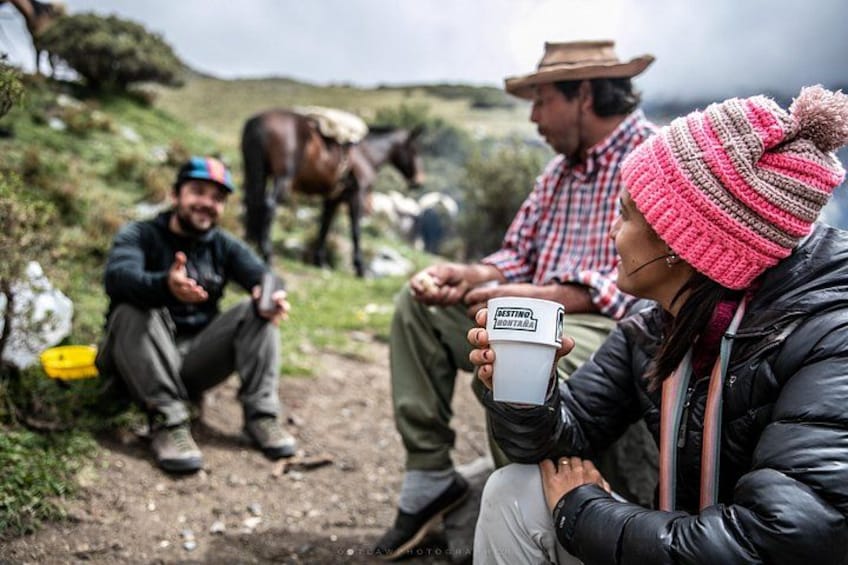 A group of people sitting outdoors with a horse in the background. 5