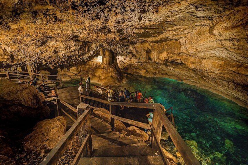 A cave with a wooden walkway and clear water. 5