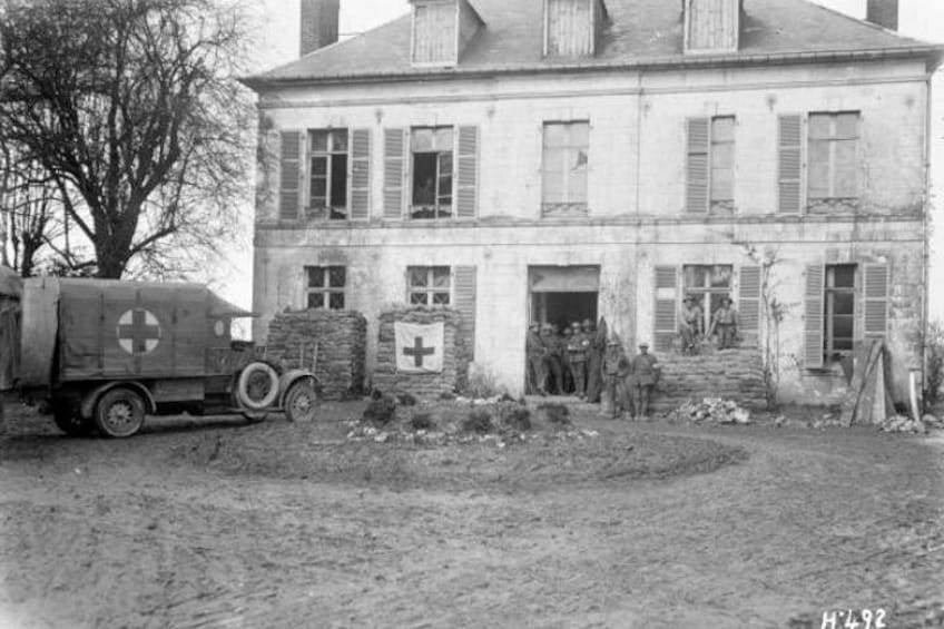 A building with a truck and a group of people in front. 3
