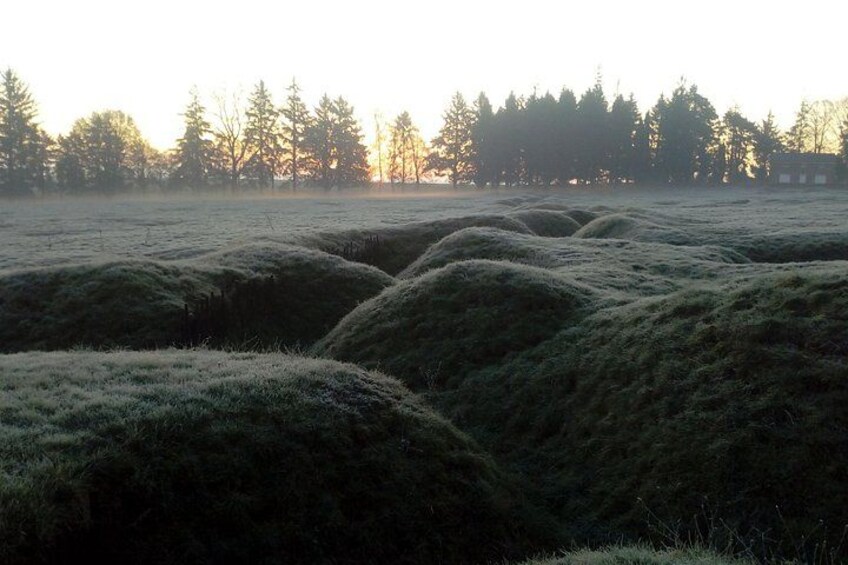 A frosty field with rolling hills and a forest in the background. 2