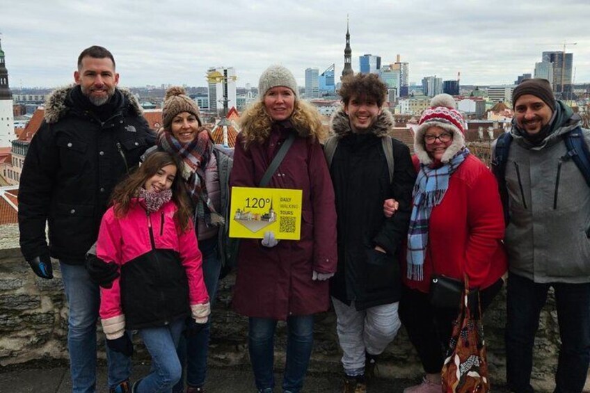 Un grupo de personas de pie en una azotea, con un paisaje urbano al fondo. 2