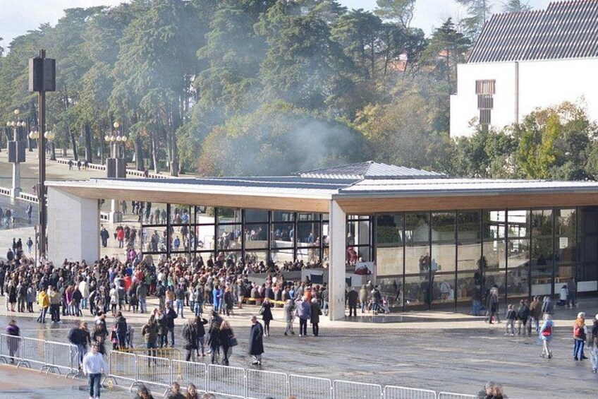 Una plaza pública concurrida, con arquitectura moderna, incluyendo un edificio de cristal y una zona cubierta. 3